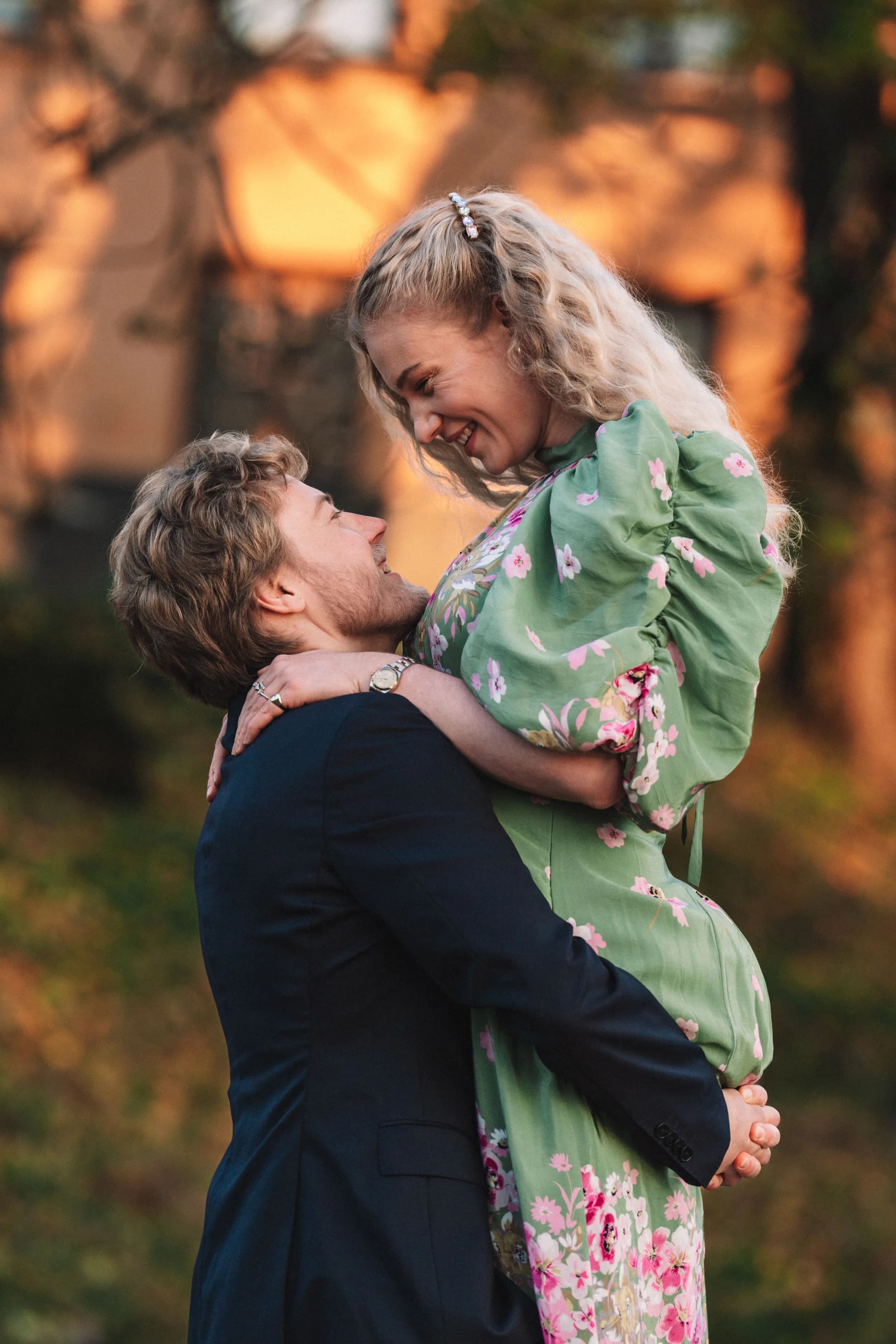 Paret ler i en omfavnelse i varmt kveldslys